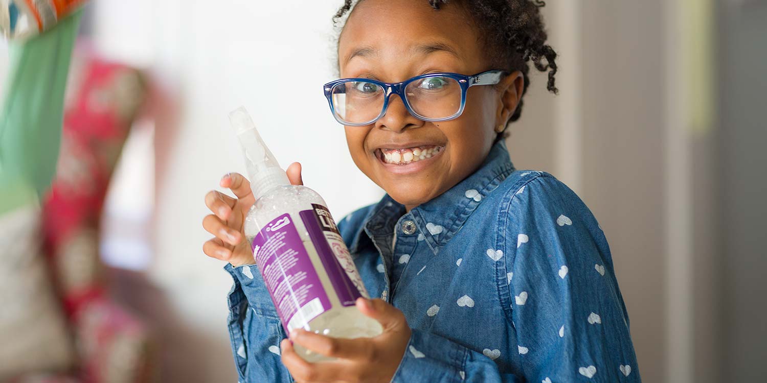 A young girl with a huge smile holding up a Better Life product in her hands